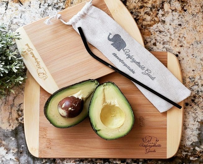 A cutting board with two halves of an avocado on it.