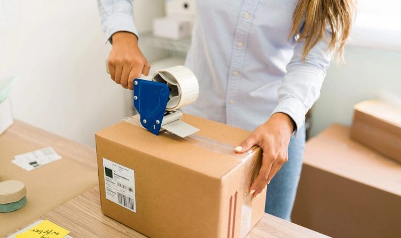 A person is taping up a box with tape.