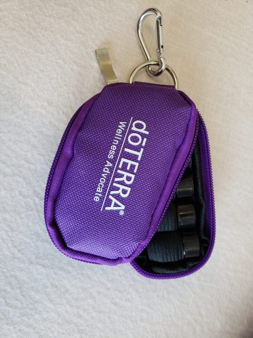 A purple doterra case with a key chain.