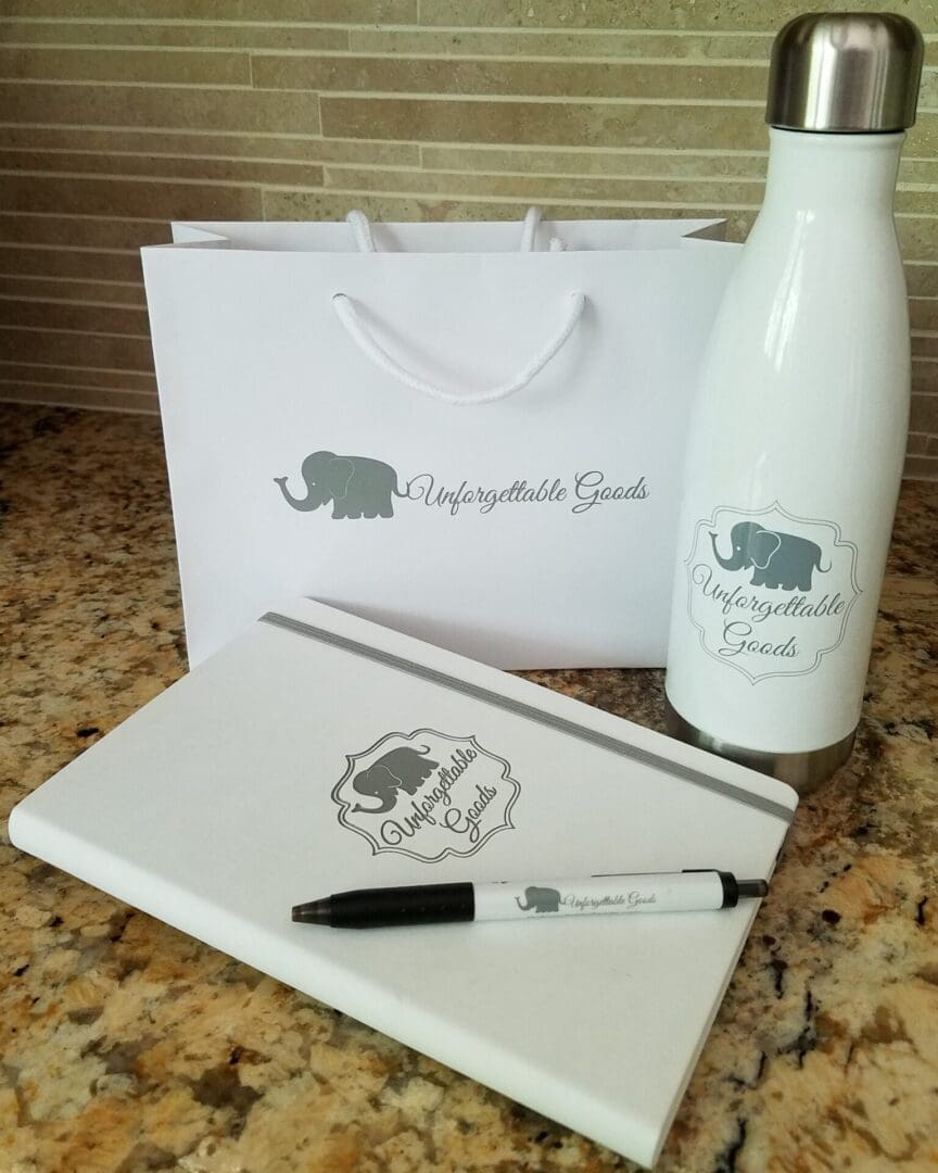 A white bag, water bottle and notebook on the counter.