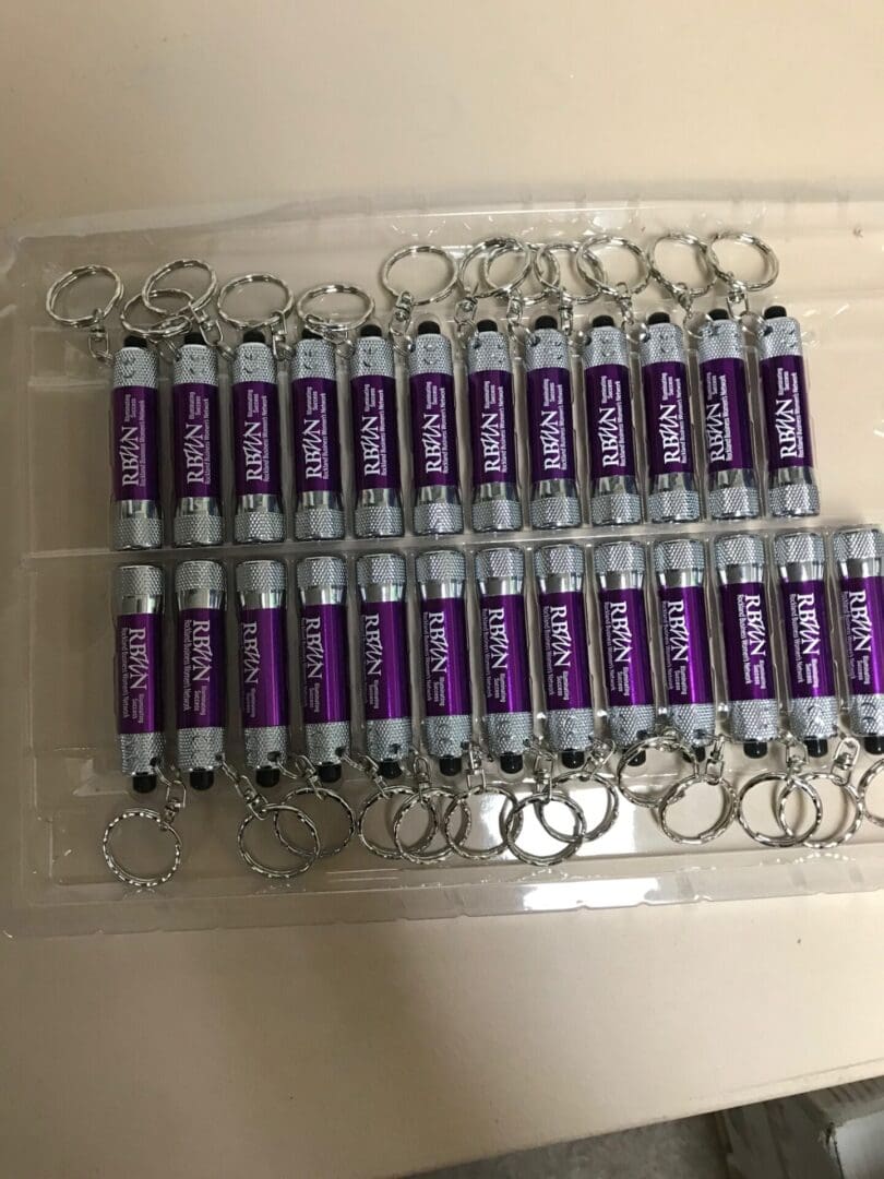 A bunch of purple batteries are on top of a clear tray.