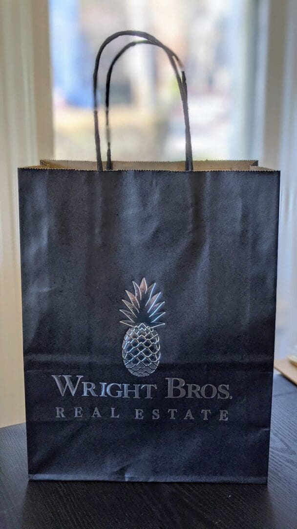 A black bag with the logo of wright bros. Real estate